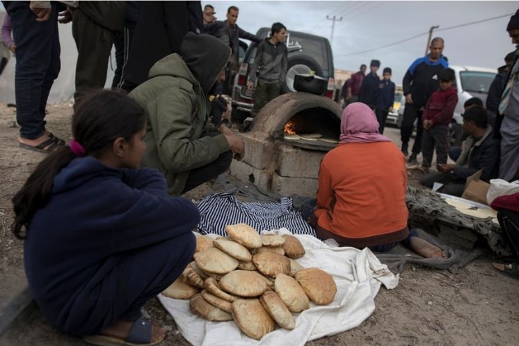 Criança e adultos se alimentando em Gaza