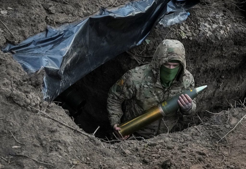 Soldado ucraniano segurando munição de artilharia