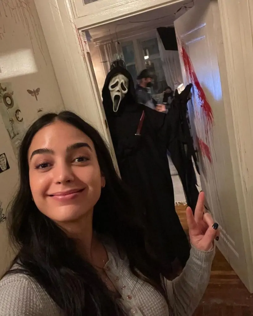 Foto da atriz Melissa Barrera apontando para o personagem Ghostface.