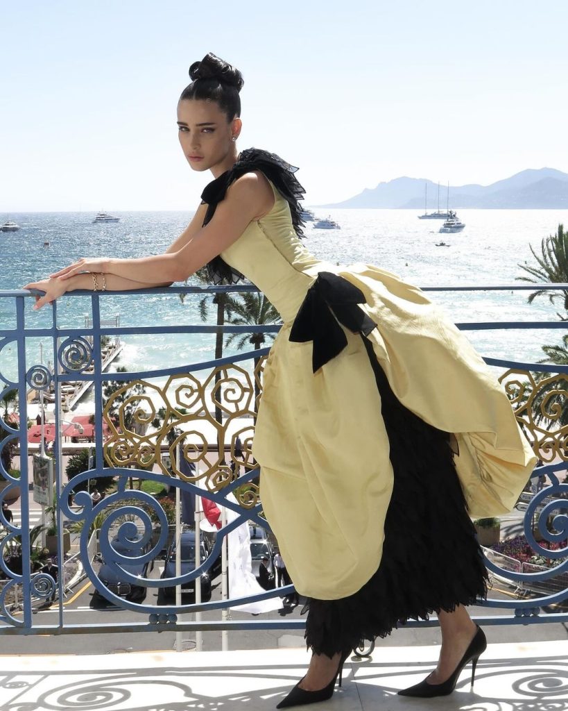 Lívia Nunes posando com vestido preto e amarelo.