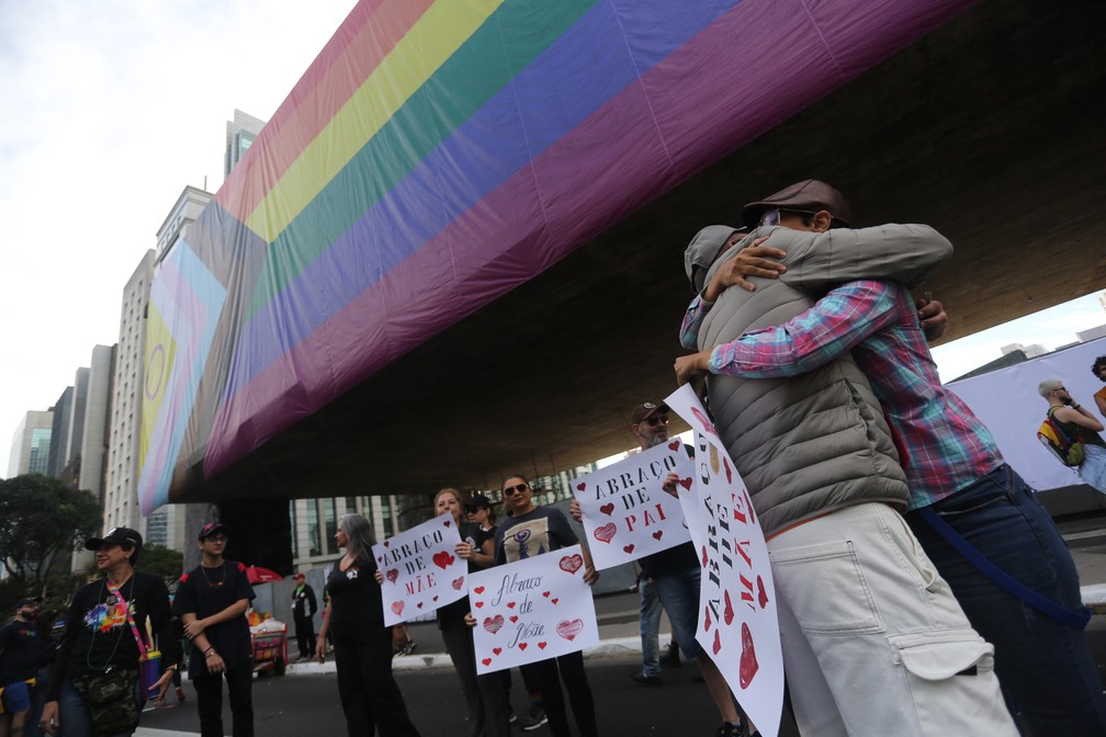 Familiares de jovens LGBT+ distribuindo abraços de pai e mãe durante a Parada